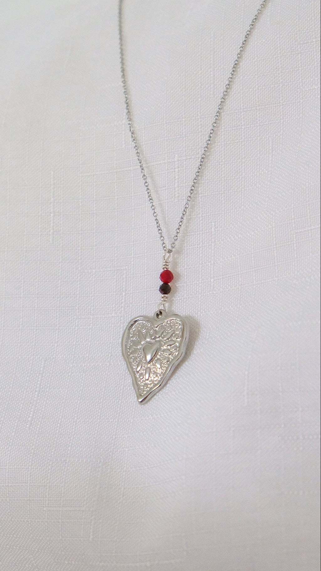 Silver heart-shaped pendant necklace on a white background