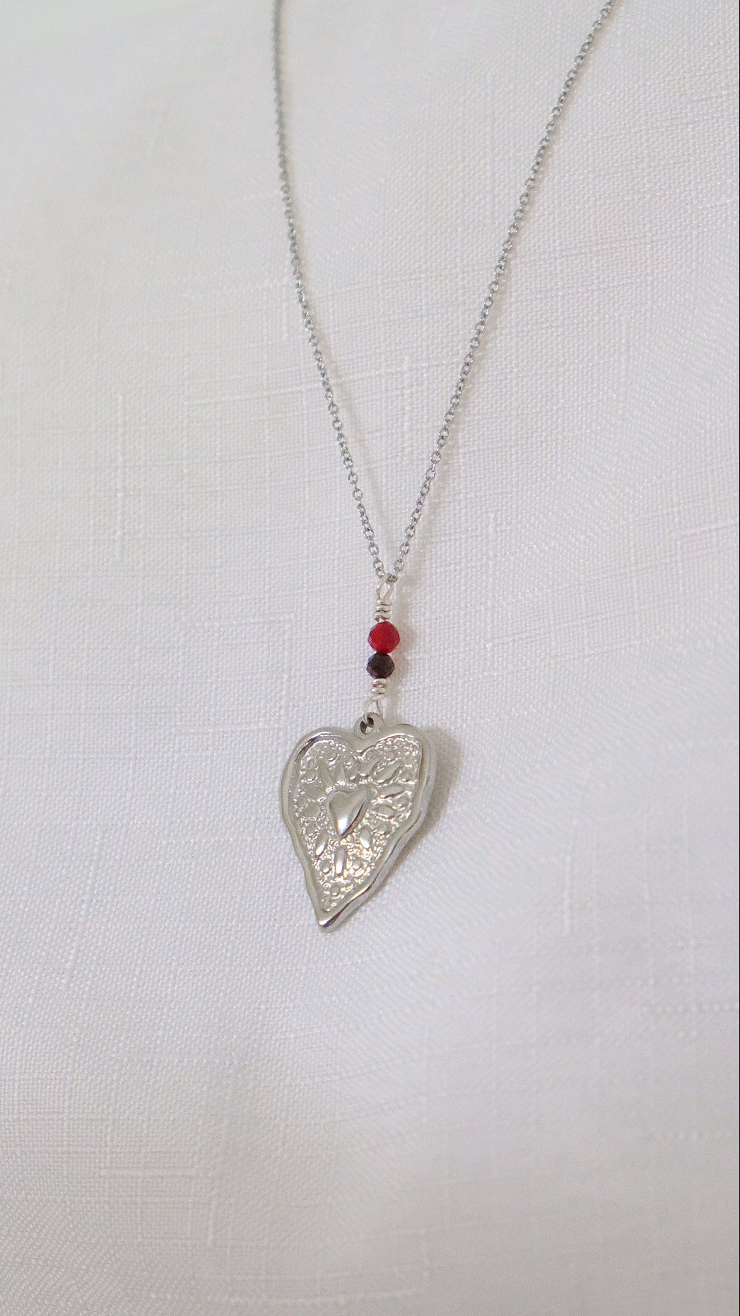 Silver heart-shaped pendant necklace on a white background